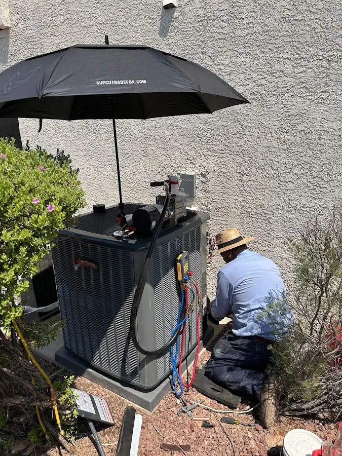 HVAC technician performing outdoor AC maintenance in Plymouth